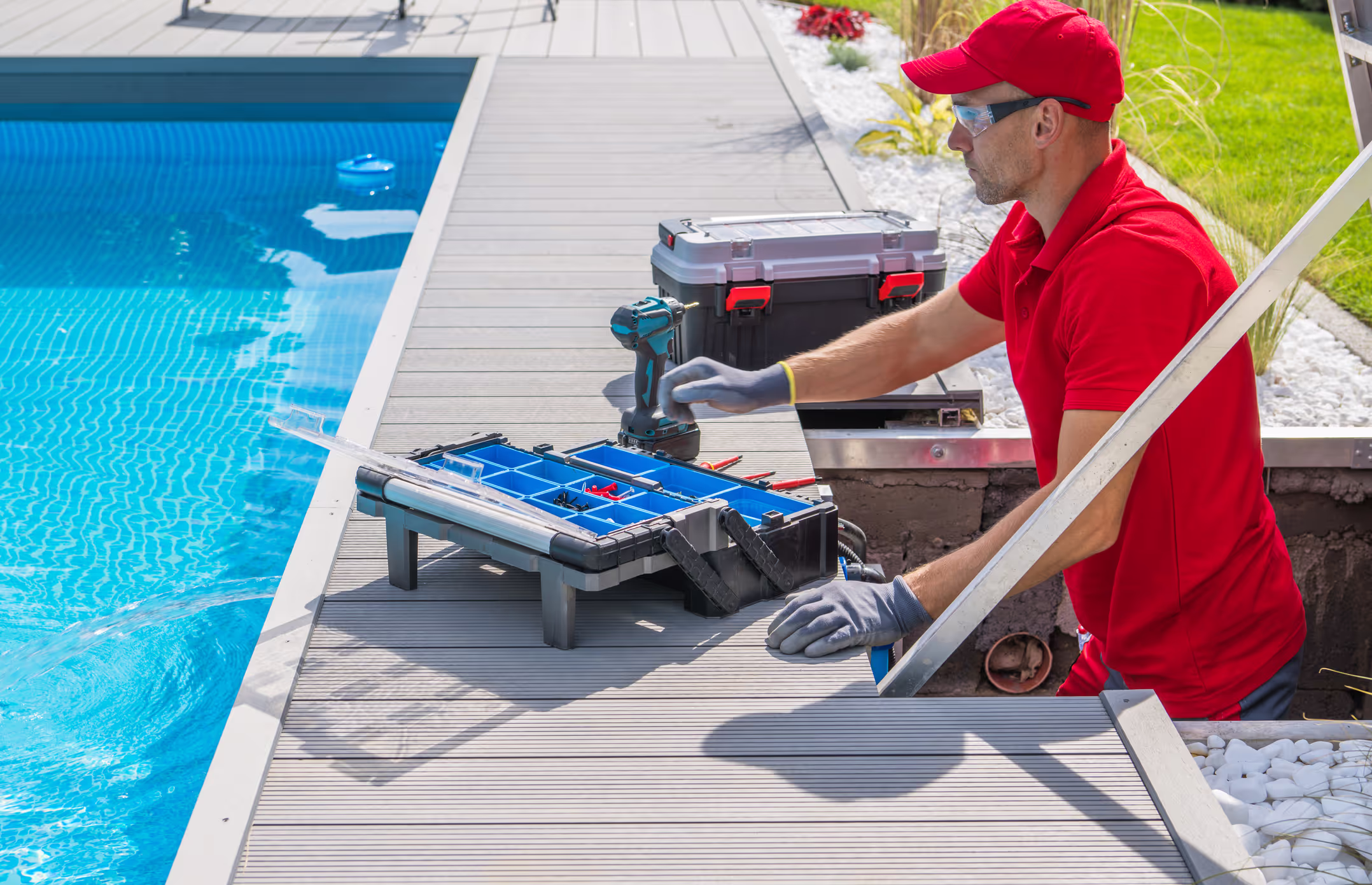 A man in a red shirt using a handheld tool on a field service job.